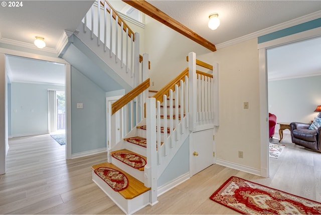 stairs featuring a textured ceiling, crown molding, vaulted ceiling, and hardwood / wood-style flooring