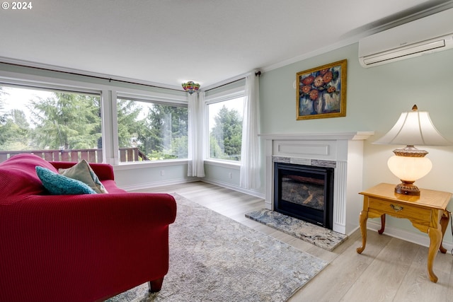 living room with light wood-type flooring, a healthy amount of sunlight, an AC wall unit, and a high end fireplace