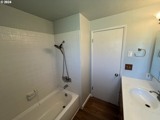 bathroom with vanity, tiled shower / bath, and hardwood / wood-style flooring