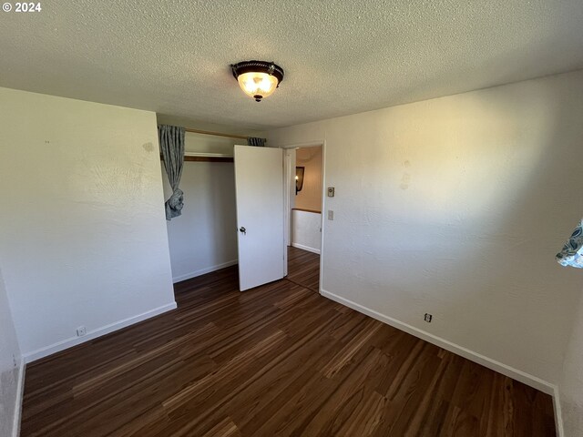 interior space with dark hardwood / wood-style flooring and a textured ceiling