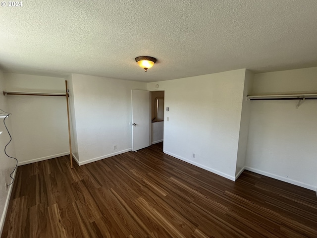 unfurnished bedroom with a textured ceiling, dark wood-type flooring, and a closet