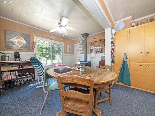 carpeted dining room featuring ceiling fan and crown molding