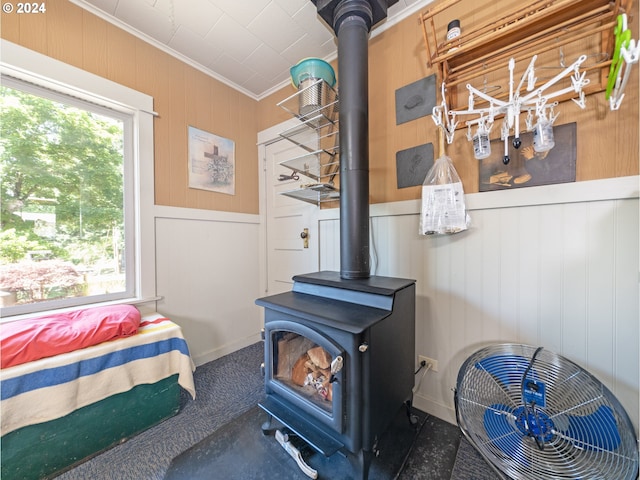 bedroom featuring a wood stove and ornamental molding