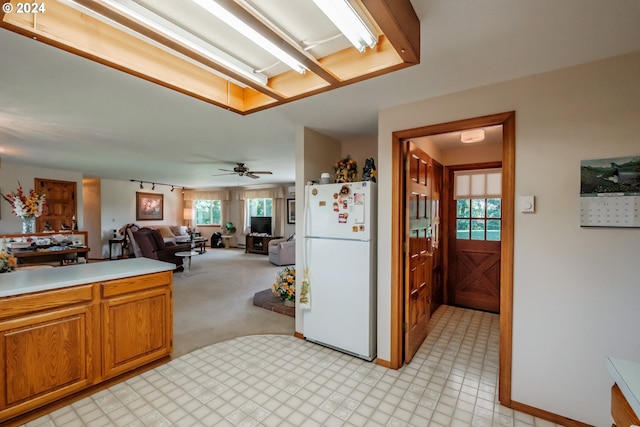 kitchen with ceiling fan, white fridge, and light carpet