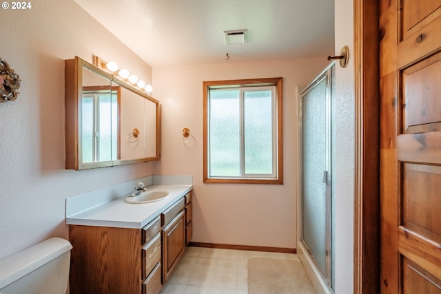 bathroom featuring vanity, toilet, and an enclosed shower