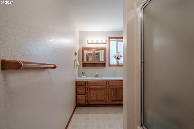 bathroom with vanity and a shower with door