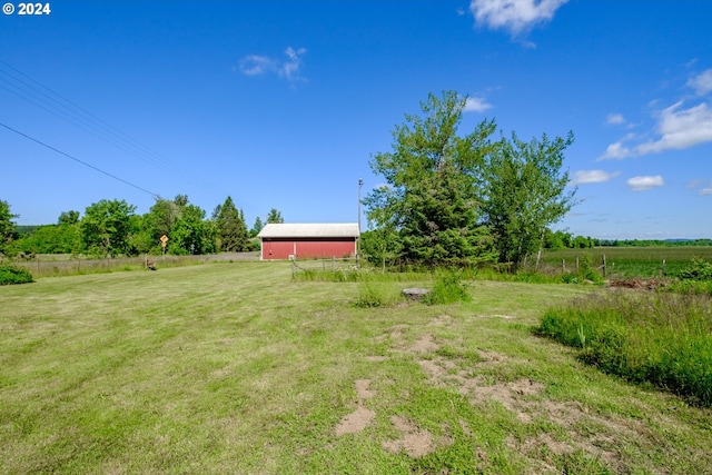 view of yard featuring a rural view and an outbuilding