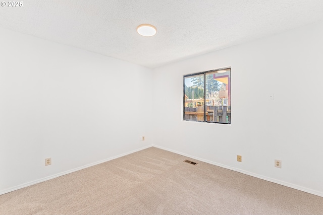 carpeted empty room with a textured ceiling