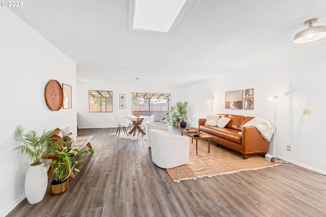 living room featuring wood-type flooring and a textured ceiling