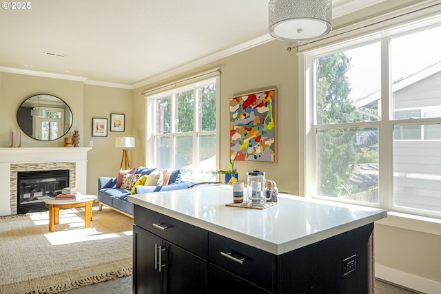 3050 SE 50th Ave Unit 6, Portland, OR 97206 - kitchen featuring dark cabinets, light countertops, ornamental molding, open floor plan, and a glass covered fireplace