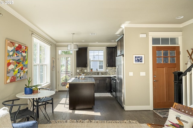 3050 SE 50th Ave Unit 6, Portland, OR 97206 - kitchen featuring a kitchen island, light countertops, ornamental molding, a sink, and dark wood finished floors