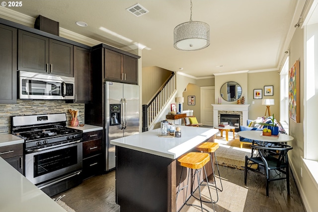 3050 SE 50th Ave Unit 6, Portland, OR 97206 - kitchen featuring stainless steel appliances, dark wood-type flooring, crown molding, dark brown cabinetry, and light countertops