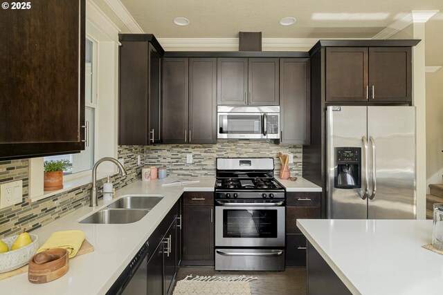 3050 SE 50th Ave Unit 6, Portland, OR 97206 - kitchen with stainless steel appliances, a sink, dark brown cabinets, crown molding, and backsplash