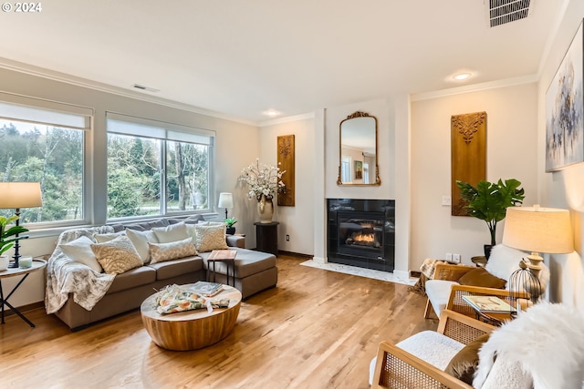 20160 SW 58th Ter, Tualatin, OR 97062 - living area featuring visible vents, ornamental molding, a tiled fireplace, and light wood-type flooring