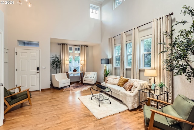 20160 SW 58th Ter, Tualatin, OR 97062 - living room featuring light wood-style floors, a towering ceiling, and a healthy amount of sunlight