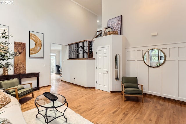 20160 SW 58th Ter, Tualatin, OR 97062 - living room featuring a decorative wall, stairway, light wood finished floors, and a towering ceiling