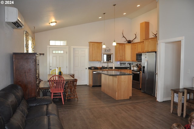 kitchen with hanging light fixtures, a wall unit AC, appliances with stainless steel finishes, dark wood-type flooring, and a kitchen island