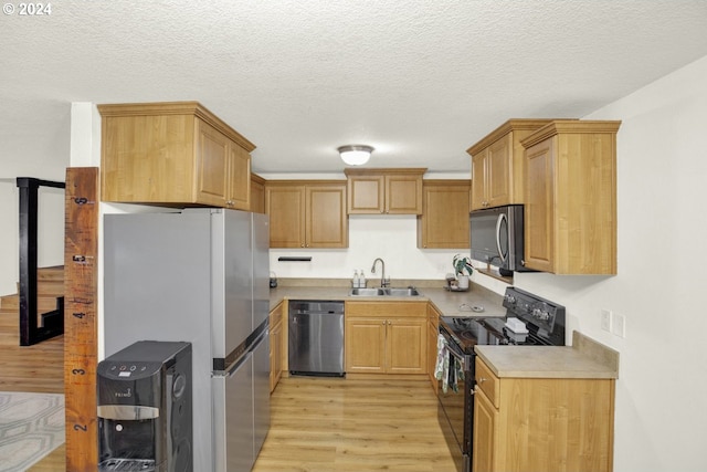 19500 S Rockie Dr, Mulino, OR 97042 - kitchen with stainless steel appliances, light wood-style flooring, a sink, light countertops, and a textured ceiling