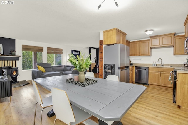 19500 S Rockie Dr, Mulino, OR 97042 - kitchen featuring stainless steel appliances, a sink, open floor plan, light countertops, and light wood-style floors