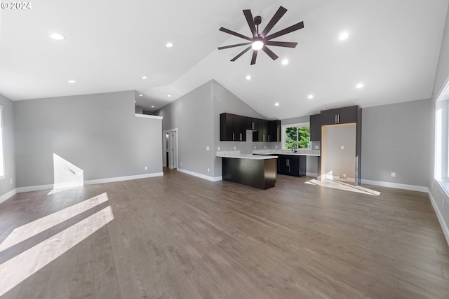 unfurnished living room featuring high vaulted ceiling, dark wood-type flooring, and ceiling fan