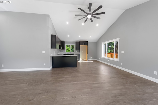 unfurnished living room with dark wood-type flooring, high vaulted ceiling, and ceiling fan