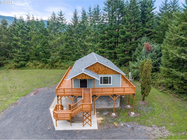 cabin with a front lawn and a carport