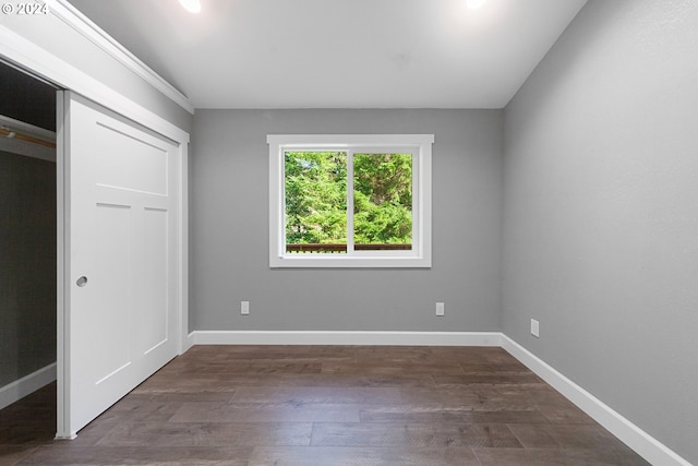 unfurnished bedroom featuring dark wood-type flooring and a closet