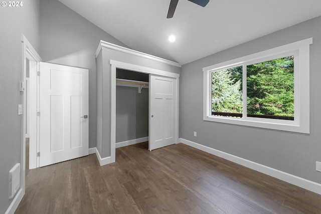 unfurnished bedroom with a closet, ceiling fan, vaulted ceiling, and dark hardwood / wood-style floors