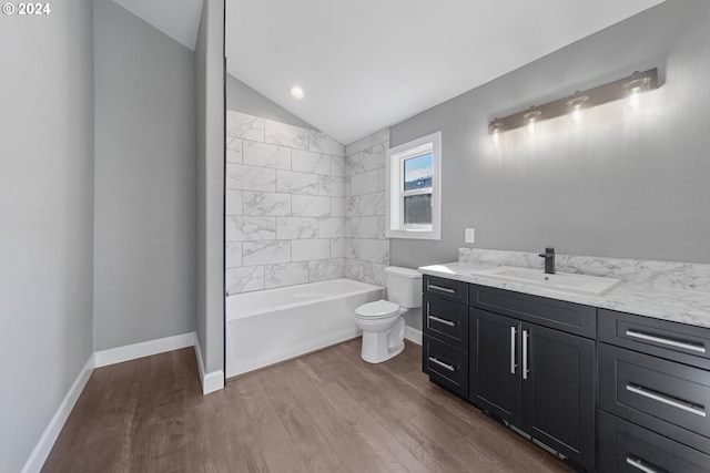 full bathroom with lofted ceiling, wood-type flooring, toilet, vanity, and tiled shower / bath combo