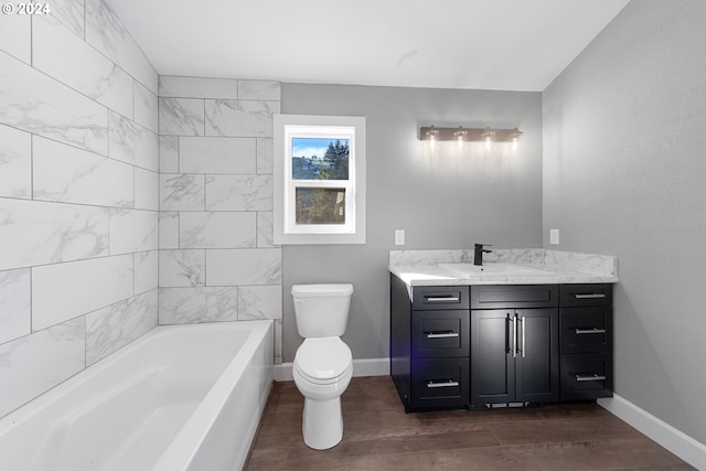 bathroom with vanity, wood-type flooring, toilet, and a bathing tub