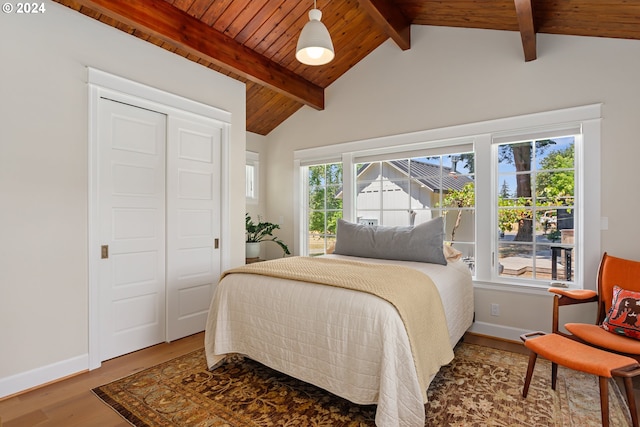 bedroom featuring hardwood / wood-style floors, lofted ceiling with beams, a closet, and wooden ceiling