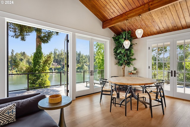 sunroom featuring a water view, french doors, and vaulted ceiling with beams