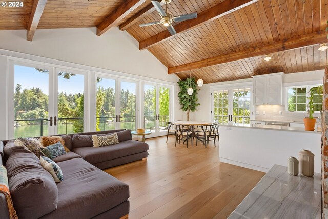 living room featuring french doors, vaulted ceiling with beams, light hardwood / wood-style floors, and wooden ceiling