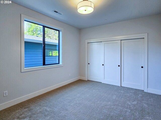 unfurnished bedroom with a closet and carpet flooring