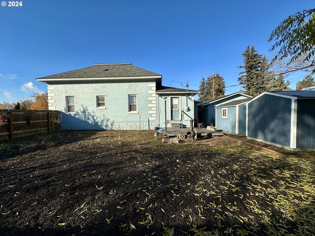 rear view of property with a storage unit