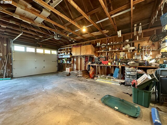 garage with a workshop area and a garage door opener