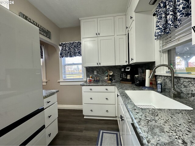 kitchen with white cabinetry, sink, dark wood-type flooring, and tasteful backsplash