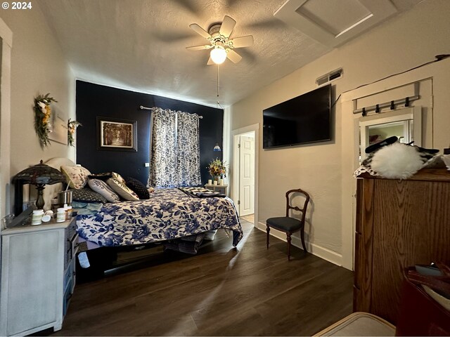 bedroom with a textured ceiling, dark hardwood / wood-style floors, and ceiling fan