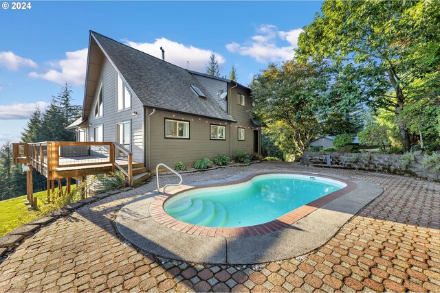 view of pool with a wooden deck and a patio area