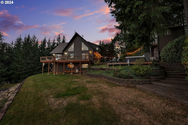 40700 NE Skye View Dr, Washougal, WA 98671 - back of property at dusk with stairway, a wooden deck, and a lawn