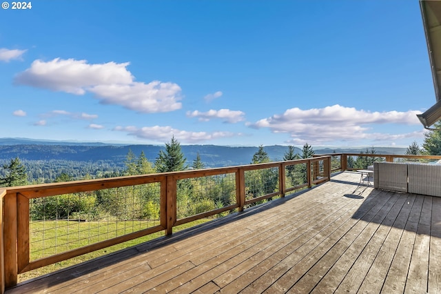 deck with a mountain view and a yard