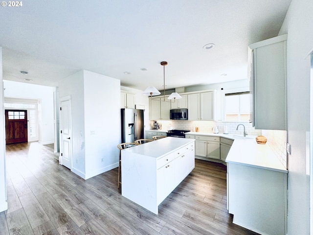 kitchen featuring appliances with stainless steel finishes, a wealth of natural light, decorative light fixtures, and a kitchen island