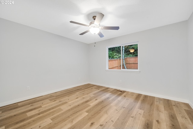 spare room with light wood-type flooring and ceiling fan