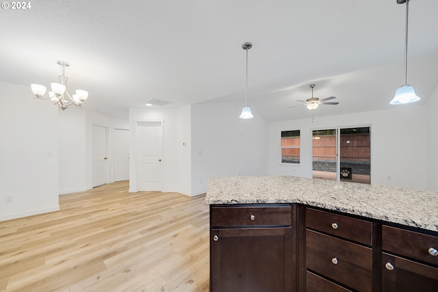 kitchen with lofted ceiling, decorative light fixtures, ceiling fan with notable chandelier, and light wood-type flooring