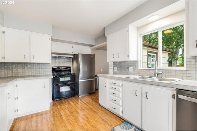 kitchen featuring sink, white cabinets, stainless steel appliances, and light hardwood / wood-style flooring