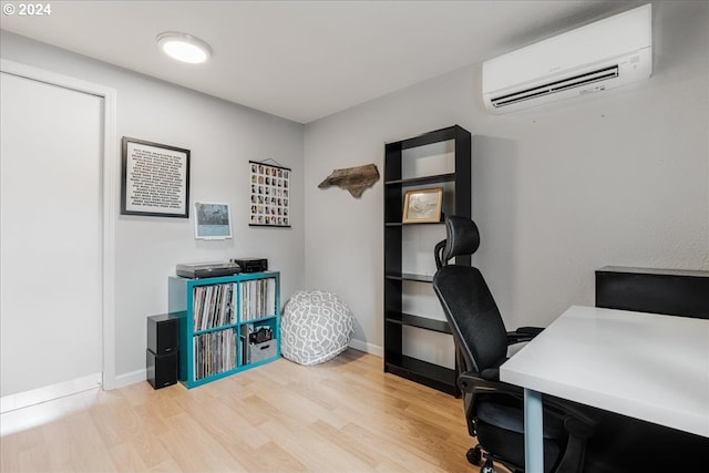 office area featuring a wall mounted AC and light hardwood / wood-style flooring