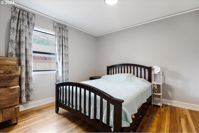 bedroom with wood-type flooring and ornamental molding