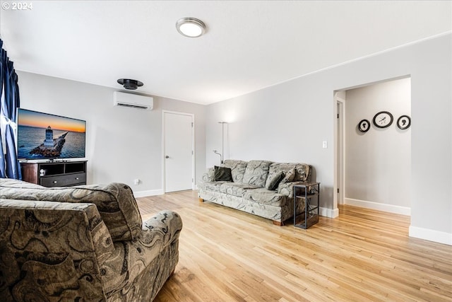 living room featuring light hardwood / wood-style flooring and an AC wall unit