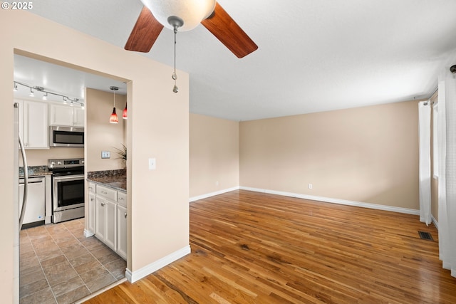 1499 Walton Way, Woodburn, OR 97071 - kitchen with appliances with stainless steel finishes, ceiling fan, white cabinetry, and light wood finished floors