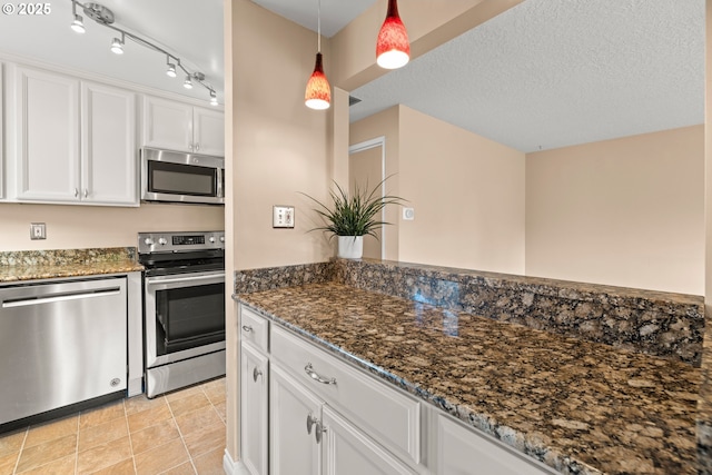1499 Walton Way, Woodburn, OR 97071 - kitchen featuring appliances with stainless steel finishes, white cabinetry, decorative light fixtures, and dark stone countertops